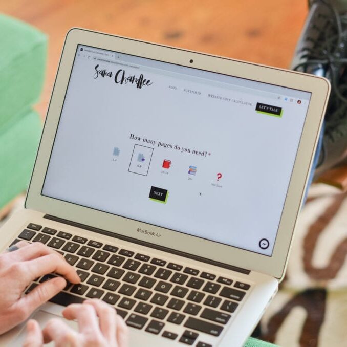 Image of computer on lap of person sitting on couch